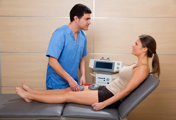 Doctor therapist checking muscle electrostimulation to woman