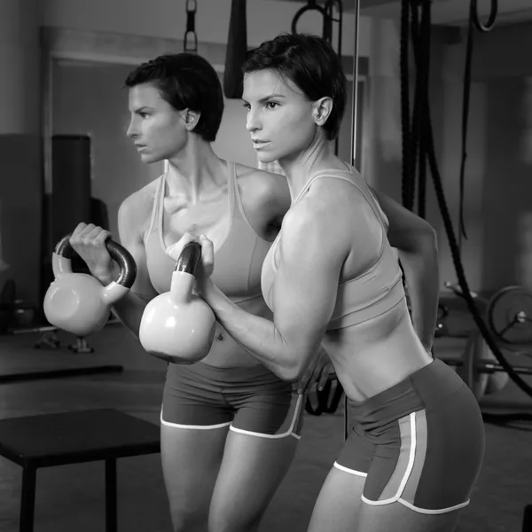 Crossfit fitness lifting Kettlebell woman at mirror workout