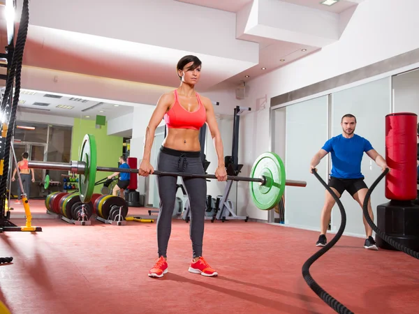 Crossfit gym weight lifting bar woman man battling ropes