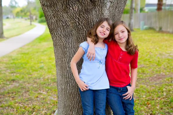 Kid friend girls whispering ear playing in a park tree
