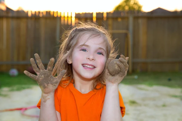 Children girl playing with mud sand ball and dirty hands