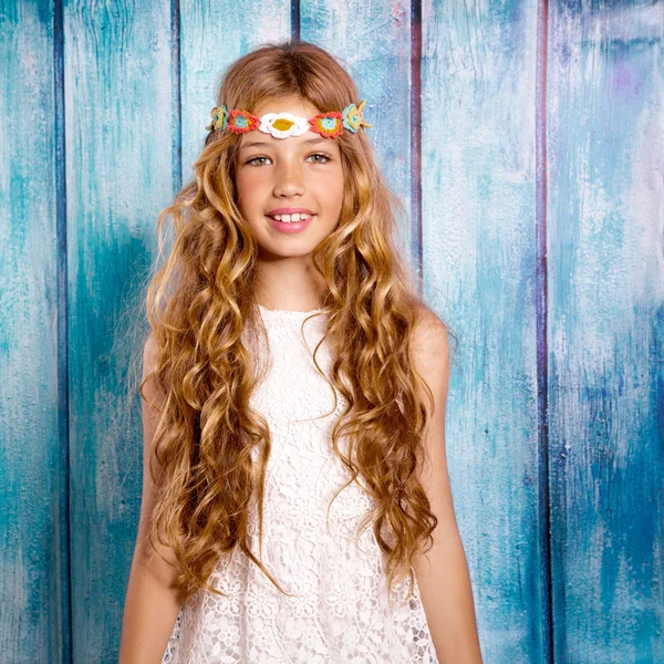Blond happy hippie children girl smiling on blue wood