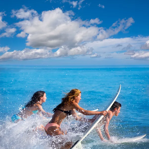 Boys and girls teen surfers surfing on surfboards