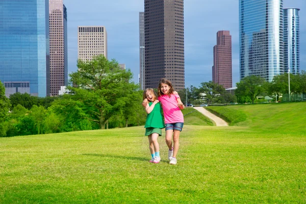 Two sister girls friends walking in urban skyline