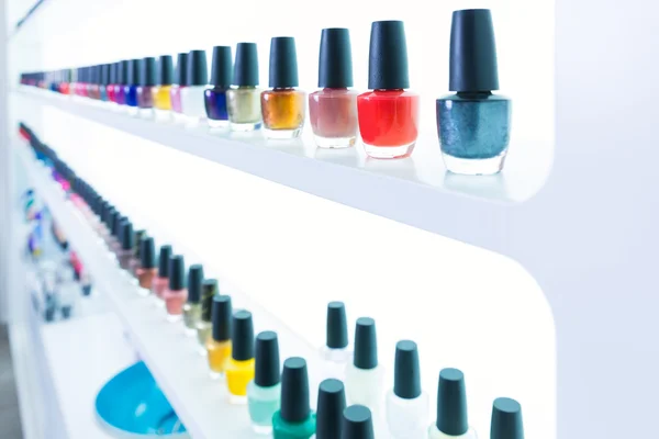Colorful nail polish colors in a row at nails saloon on white — Stock Photo #40196883