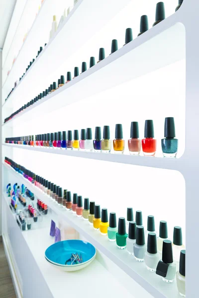 Colorful nail polish colors in a row at nails saloon on white