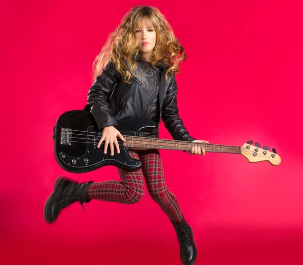Blond Rock and roll girl with bass guitar jump on red
