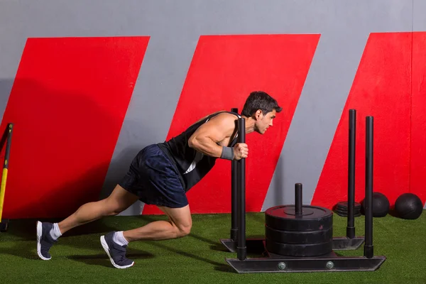 Sled push man pushing weights workout exercise