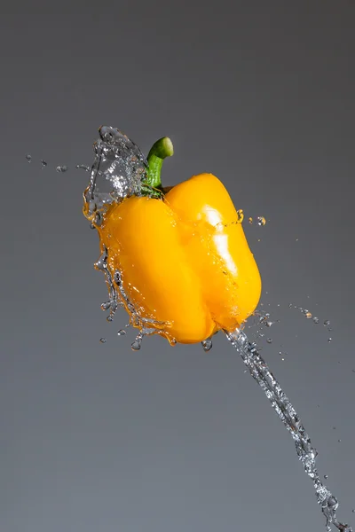 Splashing yellow pepper into water