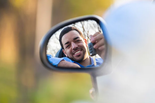 Young black latin american driver holding car keys driving his n