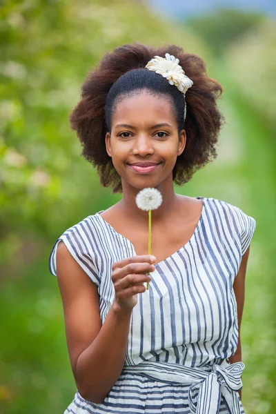 Outdoor portrait of a young beautiful african american woman hol