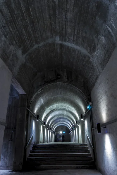 Long eerie dark concrete corridor