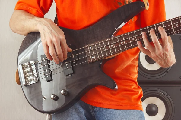 Hands of rock guitarist playing bass guitar