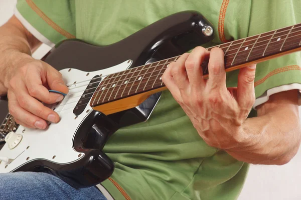 Guitarist put fingers for chords on electric guitar
