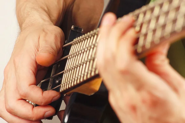 Hands of musician playing the electric bass guitar