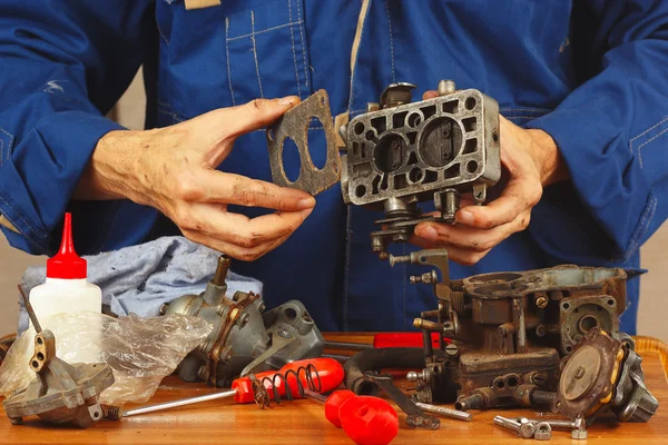 Master repairing parts of automotive engine in workshop