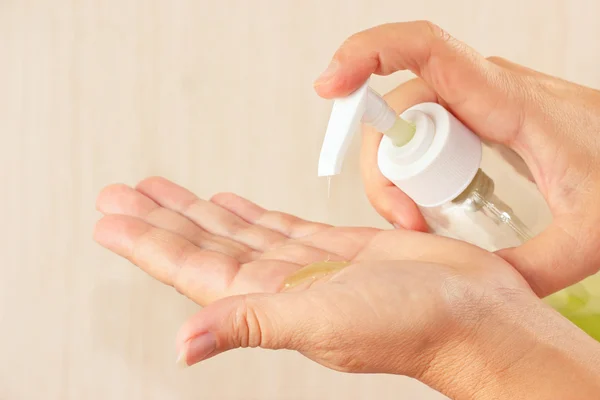 Female hands applying liquid soap