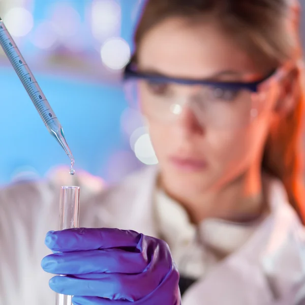 Young scientist pipetting.