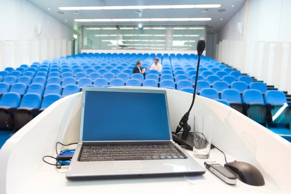 Laptop on the rostrum in conference hall.