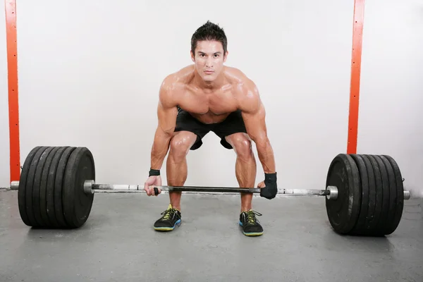 Young and muscular guy holding a barbell. Crossfit dead lift ex — Stock Photo #16040769