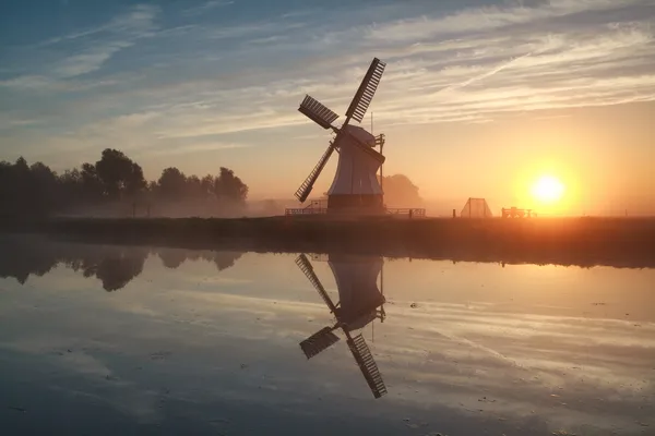 Sunrise behind Dutch windmill