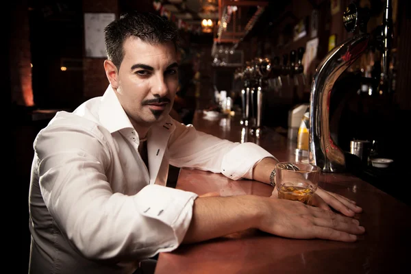 Man in shirt sitting near bar desk