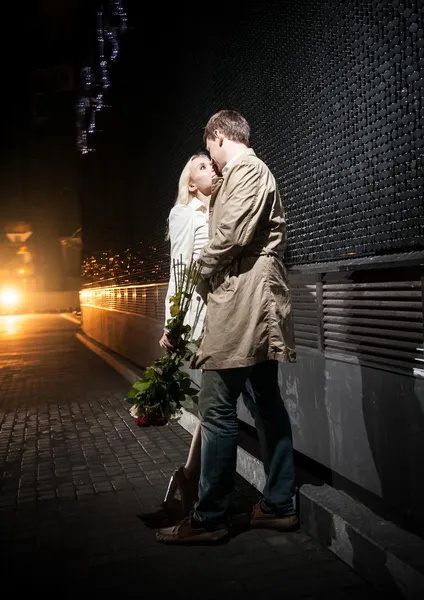 Couple in love hugging on street at night