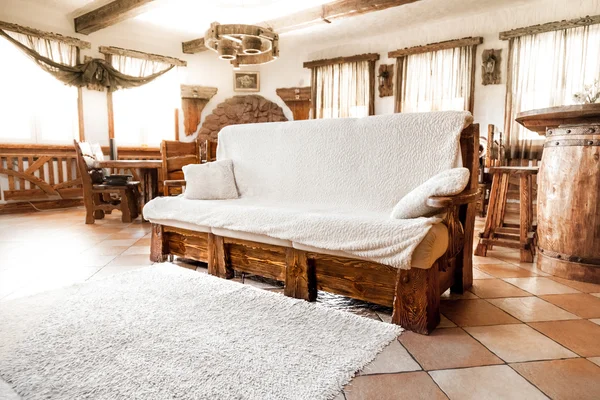 Big wooden sofa with white blanket