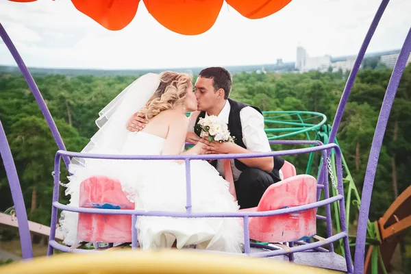 Married couple riding on Ferris wheel and kissing