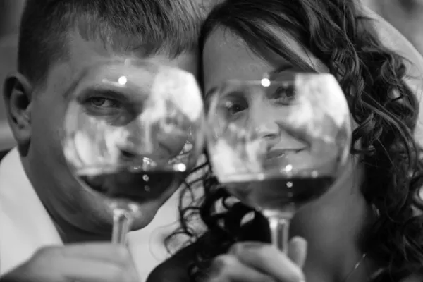 Portrait of couple in love looking through glasses of wine