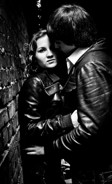 Sexy young couple hugging and leaning against wall