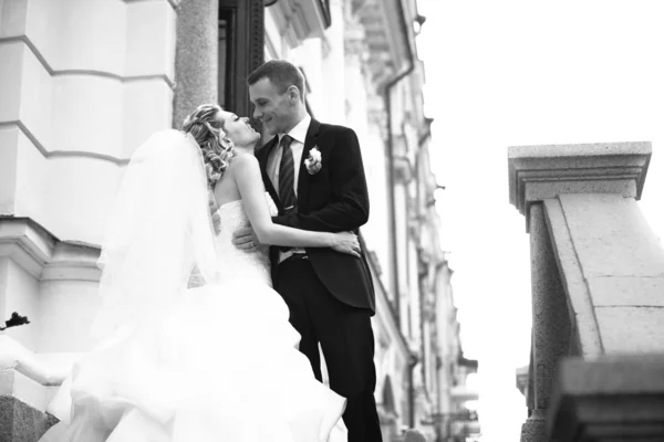 Photo of married couple kissing on stairs against building
