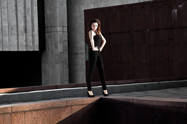 Sexy model holding hands on waist against modern building