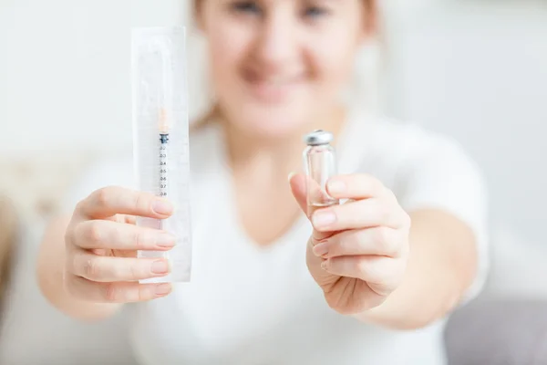 Photo of young woman holding syringe