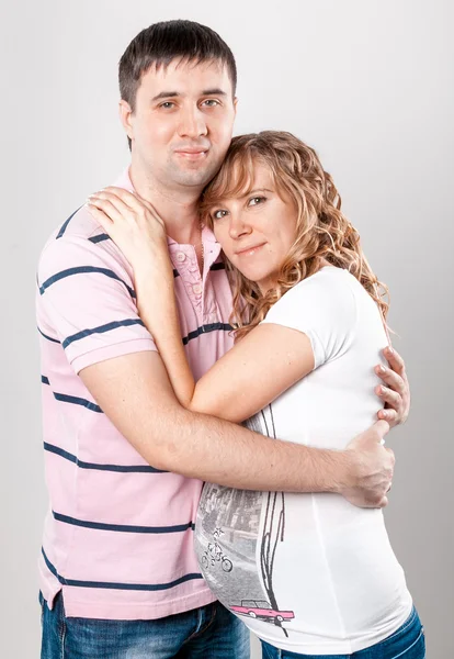 Portrait of handsome man hugging pregnant wife