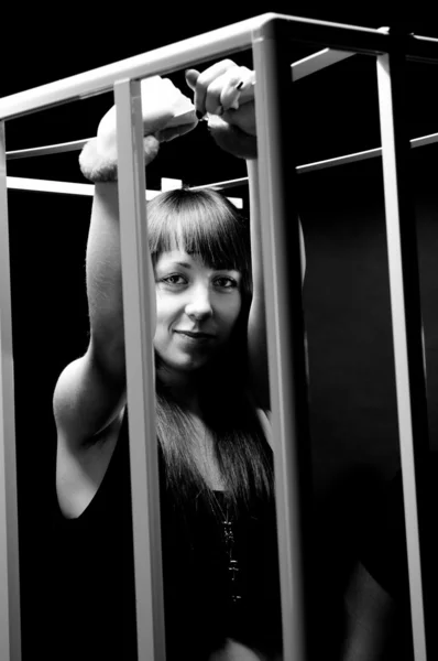Portrait of sexy woman wearing handcuffs in cage