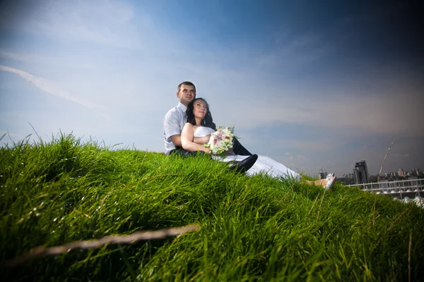 Married couple sitting on top of hill and looking at sky
