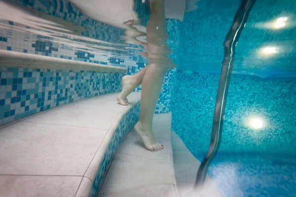Photo of woman going down the stairs in the pool