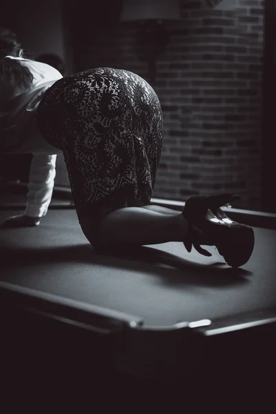 Shot of sexy woman standing on snooker table