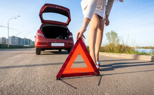 Woman putting warning sign after car crash