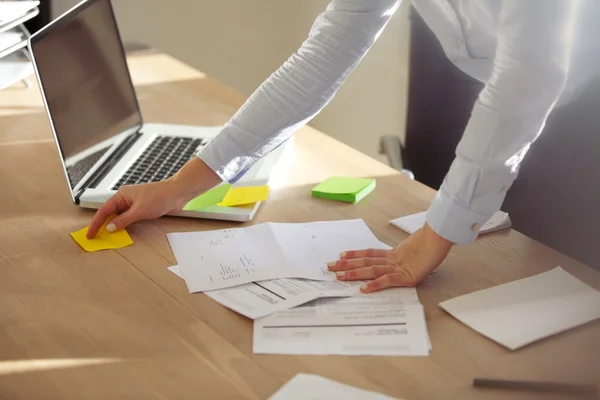 Businesswoman checking notes on post it