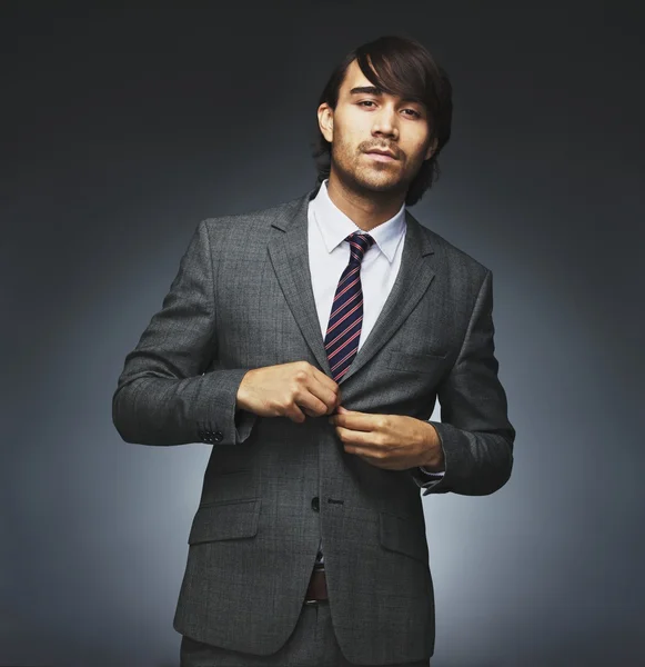 Attractive businessman getting dressed on black background