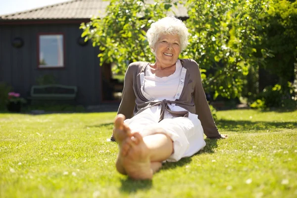 Happy elder woman sitting relaxed in garden