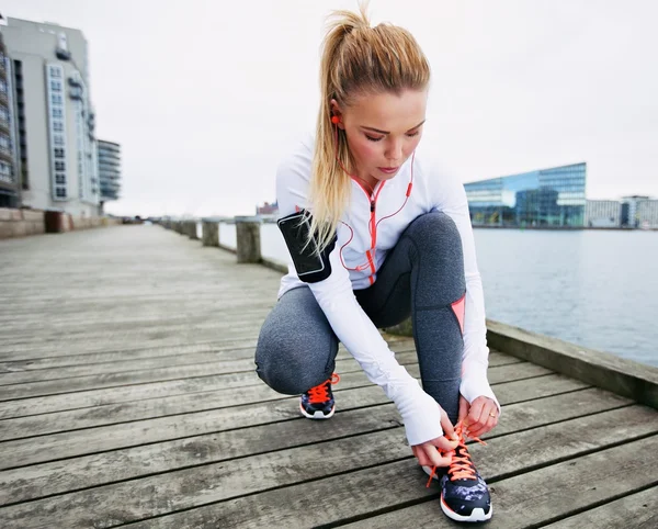 Fastening her shoelaces before the run