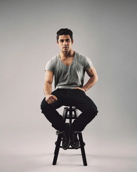 Smart young man sitting on stool
