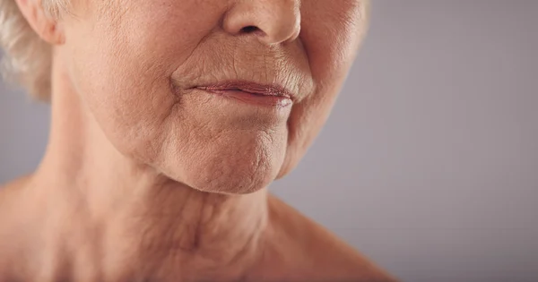 Senior female face with wrinkled skin
