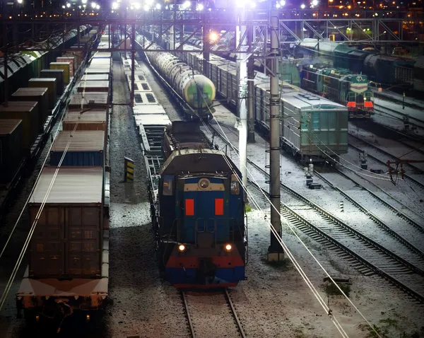 railroad night scene with lights and cargo trains