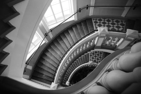 Spiral stairs with balusters. Abstract classical architecture dark interior monochrome fragment