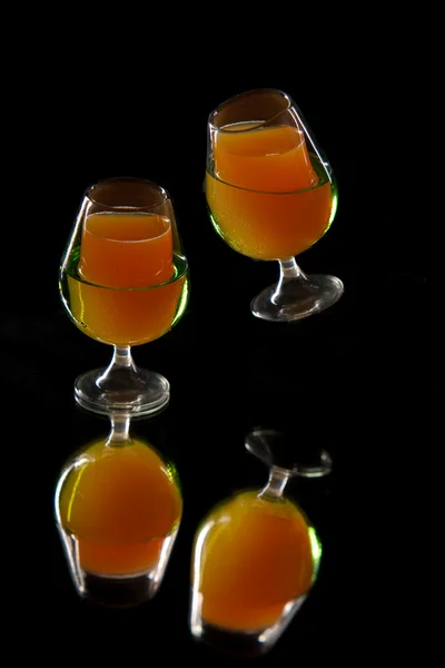 Flying orange drink in elegante glasses