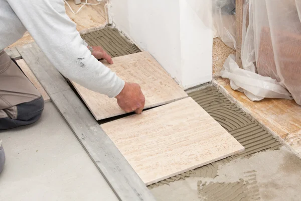 A tiler laying a tiled marble